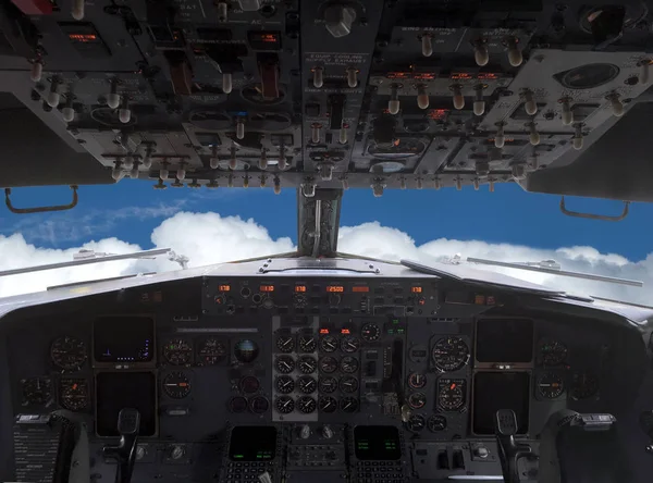 Airplane is flying above white clouds on blue sky ahead view from pilot\'s cabin