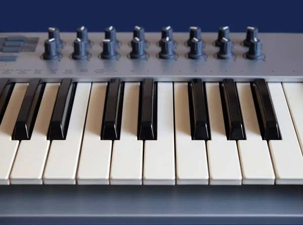 Electronic Synthesizer Keyboard Many Control Knobs Blue Background Front View Stock Image