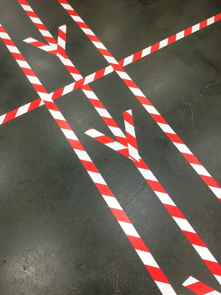 Covid 19パンデミックトップビュー中の社会的距離の遵守中に床に多くの赤と白のマーキングライン — ストック写真