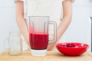 Çilekten smoothie pişirme. Smoothies için ahududu, shaker ve cam.