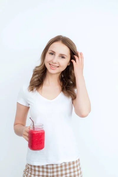 Fruta de bagas smoothie vermelho nas mãos de uma jovem garota atraente em um fundo branco . — Fotografia de Stock