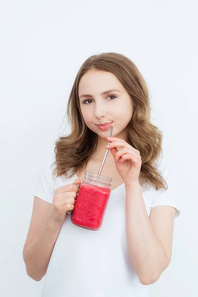 Piękna szczęśliwa młoda dziewczyna pije ekologiczne jagody, smoothie owocowe na białym tle. — Zdjęcie stockowe