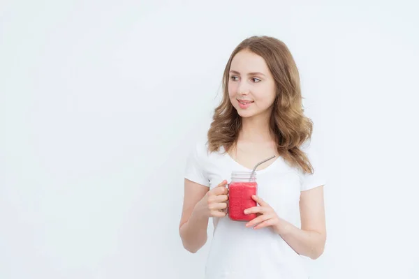 Fruta de bagas smoothie vermelho nas mãos de uma jovem garota atraente em um fundo branco . — Fotografia de Stock