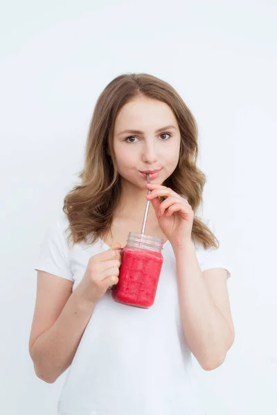 Bela menina feliz bebe baga orgânica, smoothie de frutas em um fundo branco . — Fotografia de Stock