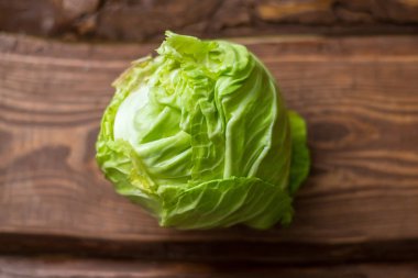 Ahşap arka plan üzerinde genç yeşil lahana Taze bütün baş.
