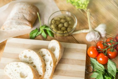 Dilimlenmiş ekmek, tahta zeminüzerine ciabatta. Bruschetta hazırlanması için hazırlık.