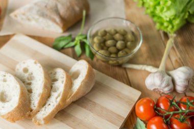 Bruschetta pişirme için Malzemeler: doğranmış ciabatta, zeytin, domates, ahşap bir arka plan üzerinde mavi peynir. Sağlıklı ve lezzetli yemekler pişirme.