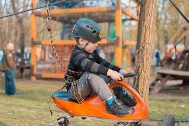 Küçük bir çocuk engelli parkurdan geçiyor. Parkta temiz havada çocuğun aktif fiziksel rekreasyon. Çocuklar için eğitim.