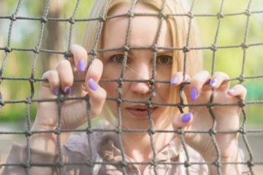 Kadının kafası karışık. İp parmaklıkların arkasındaki kadın.