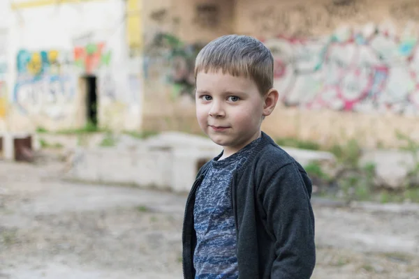 Маленький мальчик на фоне кирпичной стены . — стоковое фото