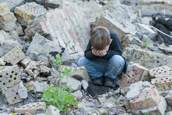Yıkılan evin yanında küçük bir çocuk. Çocuk sorunu, yalnızlık kavramı.