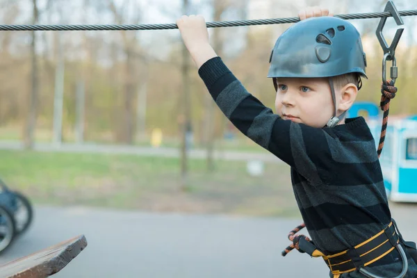 Маленький хлопчик проходить курс перешкод. Активний фізичний відпочинок дитини на свіжому повітрі в парку. Тренінг для дітей . — стокове фото