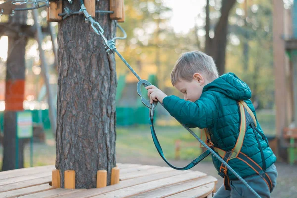 Мальчик в веревочном парке. Активный физический отдых ребенка на свежем воздухе в парке. Обучение детей . — стоковое фото