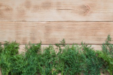 Ahşap arka plan üzerinde taze dereotu çerçevesi.