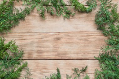 Ahşap arka plan üzerinde taze dereotu çerçevesi.