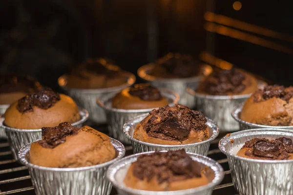 Cooked chocolate muffins in the oven. Sweet tasty cooked pastries only.