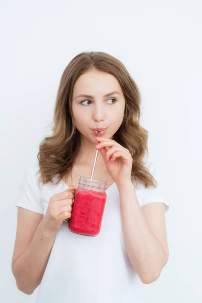 Piękna szczęśliwa młoda dziewczyna pije ekologiczne jagody, smoothie owocowe na białym tle. — Zdjęcie stockowe