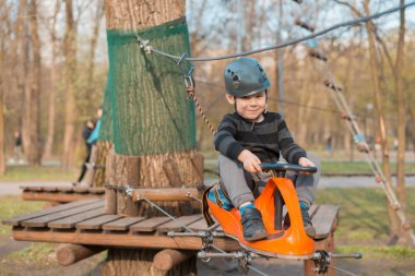 Küçük bir çocuk engelli parkurdan geçiyor. Parkta temiz havada çocuğun aktif fiziksel rekreasyon. Çocuklar için eğitim.