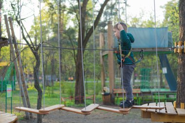 Halat parkında küçük bir çocuk. Parkta temiz havada çocuğun aktif fiziksel rekreasyon. Çocuklar için eğitim.
