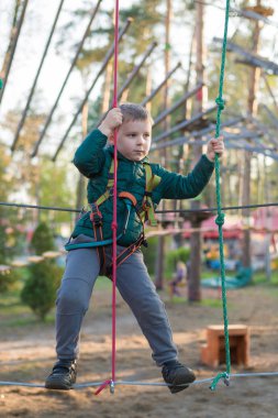 Halat parkında küçük bir çocuk. Parkta temiz havada çocuğun aktif fiziksel rekreasyon. Çocuklar için eğitim.