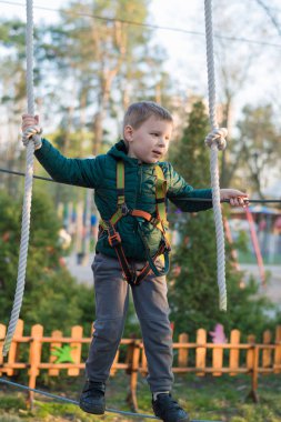 Halat parkında küçük bir çocuk. Parkta temiz havada çocuğun aktif fiziksel rekreasyon. Çocuklar için eğitim.
