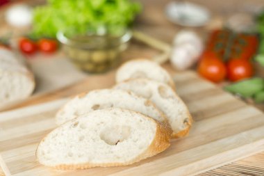 Dilimlenmiş ekmek, tahta zeminüzerine ciabatta. Bruschetta hazırlanması için hazırlık.