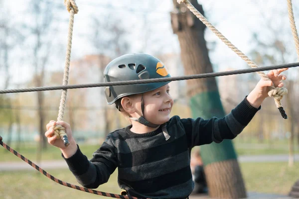 Malý chlapec prochází překážkami. Aktivní fyzické rekreace dítěte v čerstvém vzduchu v parku. Školení pro děti. — Stock fotografie