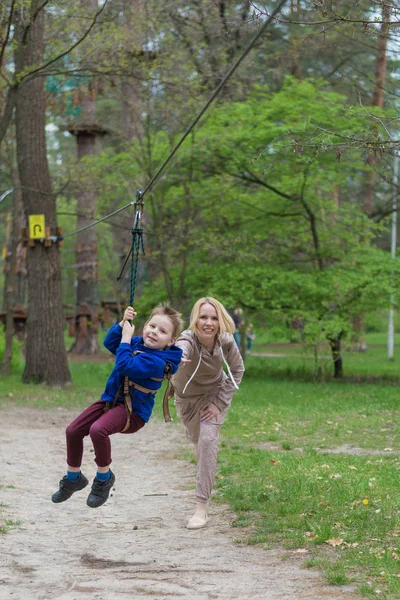 妈妈把儿子卷在缆车上。公园的休闲活动。母子互动. — 图库照片