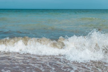Denizde dalgalar, okyanus. Yaz aylarında öğleden sonra kıyıdan deniz manzarası.