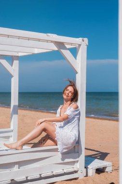 Denizde dinlenmek, okyanus. Sıcak güneşli havalarda denizde beyaz bir elbise içinde orta yaşlı bir kadın. Yaz aylarında tatile eğlenmek.