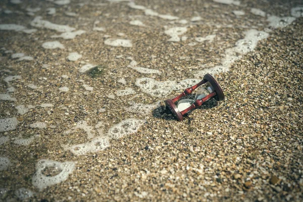 Ampulheta numa onda na praia, oceano. O conceito de transitoriedade do tempo . — Fotografia de Stock