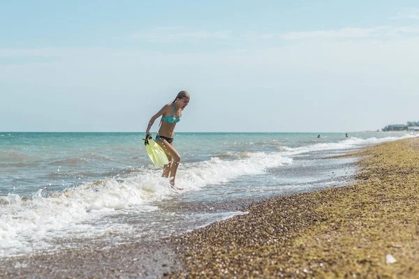 Tonåring flicka med SIM fötter i händerna på havet, havet. Sommar utomhusaktiviteter under semestern. — Stockfoto