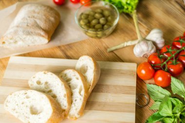 Dilimlenmiş ekmek, tahta zeminüzerine ciabatta. Bruschetta hazırlanması için hazırlık.