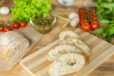 Dilimlenmiş ekmek, tahta zeminüzerine ciabatta. Bruschetta hazırlanması için hazırlık.