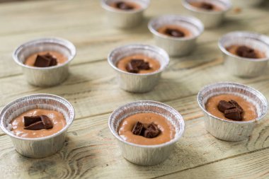 Ahşap arka plan üzerinde pişirme çanak pişirme için ham hamur. Pişirme çikolatalı kekler.