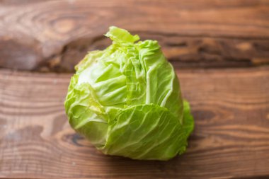Ahşap arka plan üzerinde genç yeşil lahana Taze bütün baş.