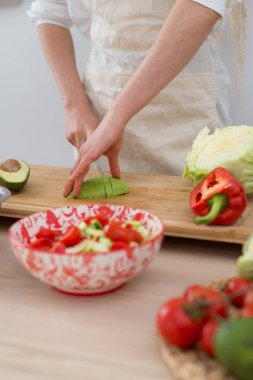 Bir kadın taze sebze salatası yapar. Vejetaryen, sağlıklı gıda.