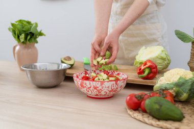 Bir kadın taze sebze salatası yapar. Vejetaryen, sağlıklı gıda.