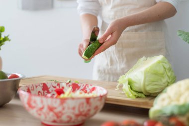 Taze sebzelerden salata pişirmek. Kadın kesme tahtasında sebze keser.