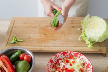 Taze sebzelerden salata pişirmek. Kadın kesme tahtasında sebze keser.