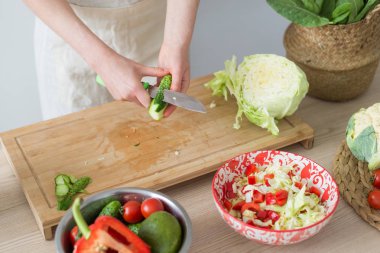 Taze sebzelerden salata pişirmek. Kadın kesme tahtasında sebze keser.