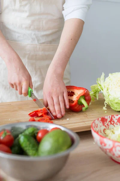 Une femme fait une salade de légumes frais. Aliments végétariens et sains . — Photo