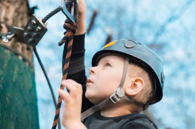 Küçük bir çocuk engelli parkurdan geçiyor. Parkta temiz havada çocuğun aktif fiziksel rekreasyon. Çocuklar için eğitim.