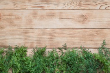 Ahşap arka plan üzerinde taze dereotu çerçevesi.