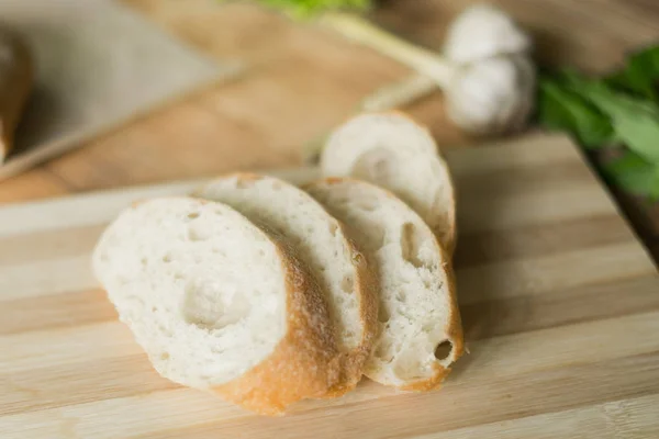 Nakrájené pečivo, ciabatta na dřevěném podkladu. Příprava na přípravu bruschetty. — Stock fotografie