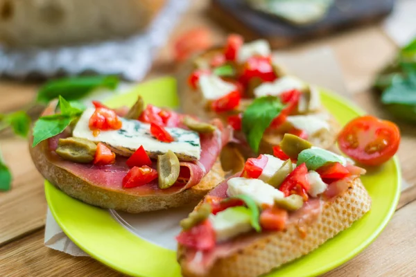 Brânză tradițională italiană cu brânză albastră, feta, roșii, frunze de busuioc, gem pe un fundal din lemn . — Fotografie, imagine de stoc