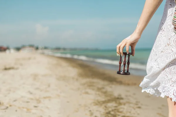 Timglas i kvinnlig hand på stranden. Tid till vila, Relax koncept. — Stockfoto