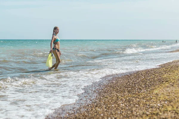 Tonåring flicka med SIM fötter i händerna på havet, havet. Sommar utomhusaktiviteter under semestern. — Stockfoto