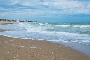 Sahilde deniz sörfü. Kıyıya gelen dalgalar.
