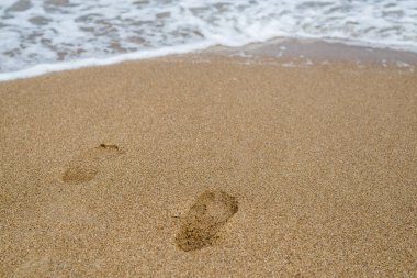 Deniz kıyısındaki kumda ayak izleri, okyanus.